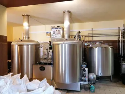 a kitchen with three large silver tanks in a kitchen at Penzion Eška s Pivovarem MJ in Jince