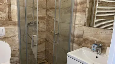a shower with a glass door next to a sink at Penzion Eška s Pivovarem MJ in Jince