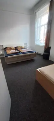 a bedroom with two beds and a window at Penzion Eška s Pivovarem MJ in Jince