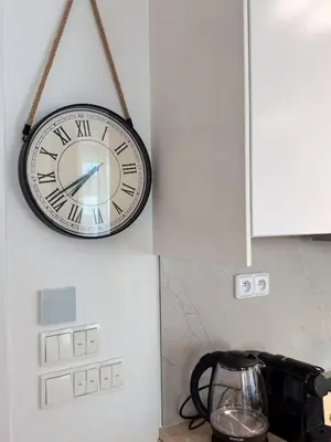 a clock hanging on a wall next to a blender at Stylish Modern Studio, Large Balcony, Prague 3 in Prague