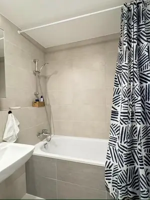 a bathroom with a bath tub and a shower curtain at Stylish Modern Studio, Large Balcony, Prague 3 in Prague