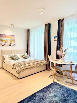 a bedroom with a bed and a table at Stylish Modern Studio, Large Balcony, Prague 3 in Prague