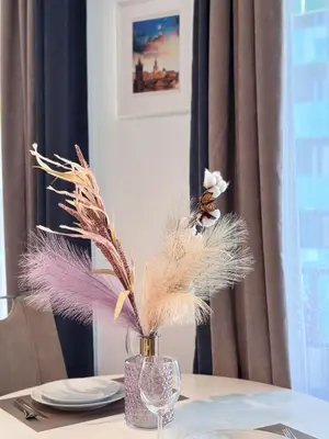 a vase filled with feathers sitting on a table at Stylish Modern Studio, Large Balcony, Prague 3 in Prague