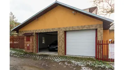 a garage with a white garage door on a house at Apartmán Vrané in Vrané nad Vltavou