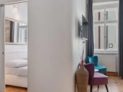 a room with a bed and a chair and a mirror at Apartment Golden Stage Nook by Interhome in Prague