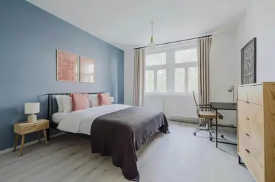 a bedroom with blue walls and a bed with pink pillows at Blueground Prague 10 equipped VŠFS University PRG-28 in Prague