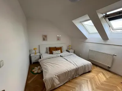 a bedroom with a bed and two windows at Modern apartment in the city centre in Prague