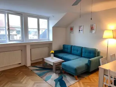a living room with a blue couch and a table at Modern apartment in the city centre in Prague