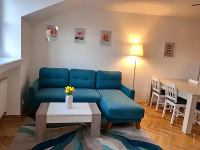 a living room with a blue couch and a table at Modern apartment in the city centre in Prague