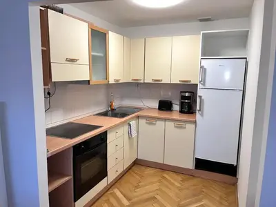 a kitchen with white cabinets and a white refrigerator at Modern apartment in the city centre in Prague