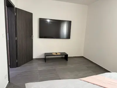 a bedroom with a bed and a tv on the wall at Byt apartman 72m2 private garden PARKING FREE in Prague