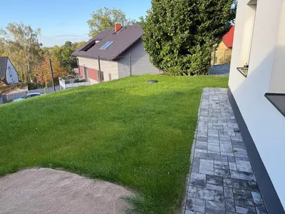 a grassy yard with a building and a house at Byt apartman 72m2 private garden PARKING FREE in Prague