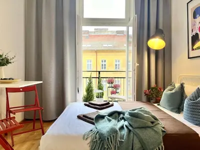 a bedroom with a bed with a blanket on it at Sunlit - Prague Apartment in Prague