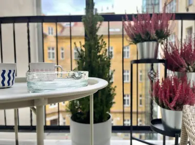 a table with christmas trees on a balcony at Sunlit - Prague Apartment in Prague