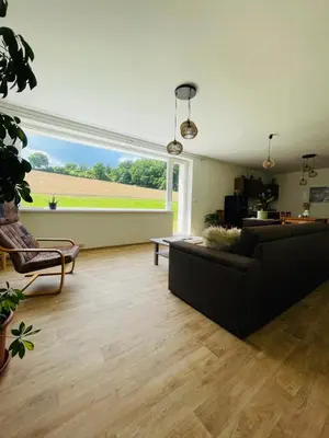 a living room with a couch and a large window at Dolpo 55 in Benešov