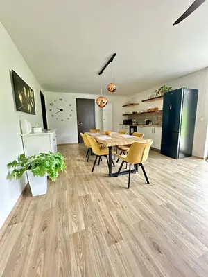 a dining room with a table and chairs and a kitchen at Dolpo 55 in Benešov