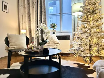 a table with books and a vase with flowers on it at Wenceslas - Prague Apartment in Prague