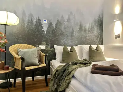 a bedroom with a bed and a chair with a forest mural at Pine - Prague Apartment in Prague