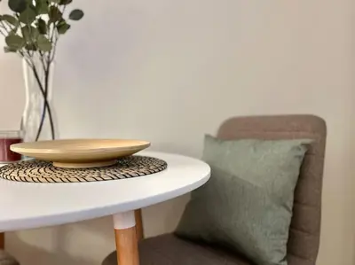 a white table with a plate and a vase on it at Pine - Prague Apartment in Prague