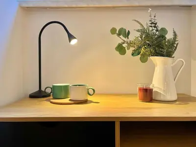 a desk with two coffee cups and a vase with a plant at Pine - Prague Apartment in Prague