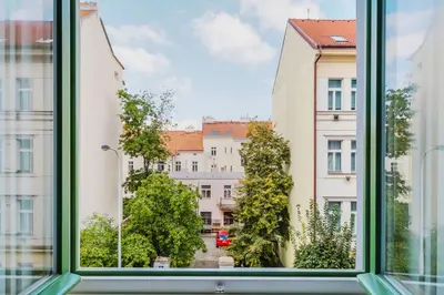 an open window with a view of buildings at Blueground Žižkov nr University of Economics PRG-36 in Prague