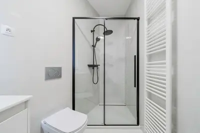 a glass shower in a bathroom with a toilet at Blueground Žižkov nr University of Economics PRG-36 in Prague
