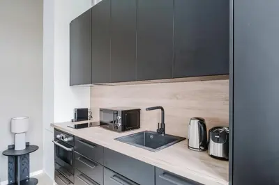 a kitchen with a sink and black cabinets at Blueground Žižkov nr University of Economics PRG-36 in Prague