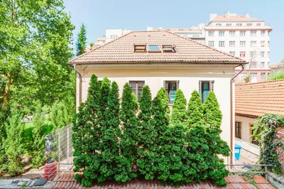a house with a large bush in front of it at Blueground Rostovska str renovated furnished PRG-19 in Prague