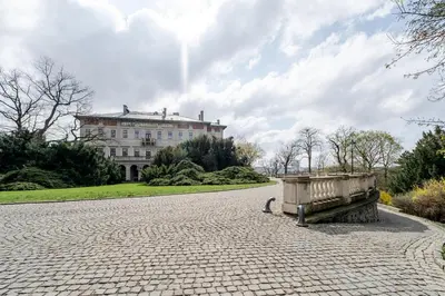 a stone road with a bench in front of a building at Blueground Rostovska str renovated furnished PRG-19 in Prague