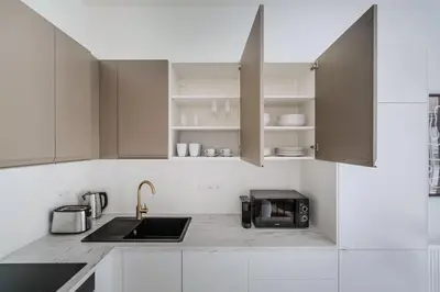 a white kitchen with a sink and a microwave at Blueground Vršovice private terrace equipped PRG-4 in Prague