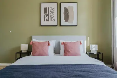 a bedroom with a large bed with pink pillows at Blueground Prague 3 shopping close to offices PRG-20 in Prague