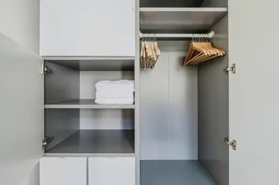 a walk in closet with white cabinets at Blueground Prague 3 shopping close to offices PRG-20 in Prague