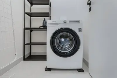 a washing machine in a bathroom with a shelf at Blueground Prague 3 shopping close to offices PRG-20 in Prague