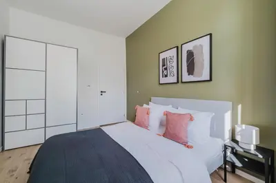 a bedroom with a large white bed with pink pillows at Blueground Prague 3 shopping close to offices PRG-20 in Prague