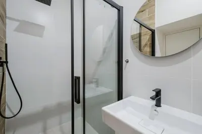 a white bathroom with a sink and a mirror at Blueground Prague 3 shopping close to offices PRG-20 in Prague