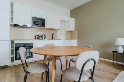 a kitchen with a wooden table and chairs at Blueground Prague 3 shopping close to offices PRG-20 in Prague