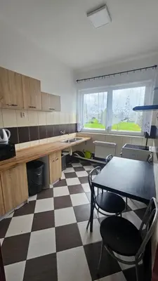 a kitchen with a table and chairs and a checkered floor at Ubytovna-Hostel- IMOS in Prague