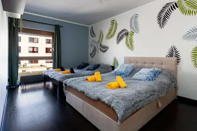 two beds in a bedroom with yellow pillows on them at Tiger Deluxe Suite in Prague