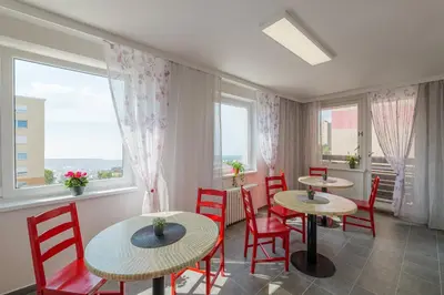 two tables and chairs in a room with windows at Cooliving in Prague
