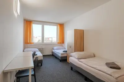 a room with two beds and a desk in it at Cooliving in Prague
