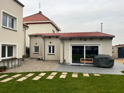 a house with a yard with a bench in front of it at Mezidomí in Budyně nad Ohří