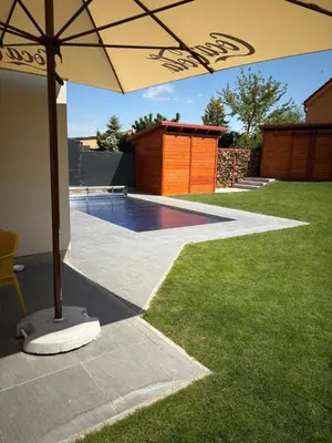 a patio with an umbrella and a swimming pool at Mezidomí in Budyně nad Ohří