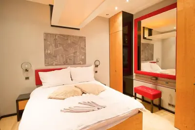 a bedroom with a large white bed with a red headboard at Apartment in the heart of Prague in Prague