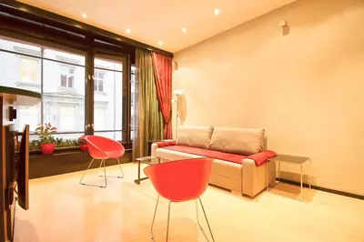 a living room with a couch and two red chairs at Apartment in the heart of Prague in Prague