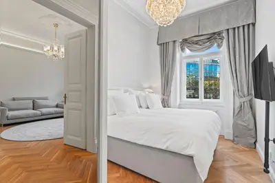a white bedroom with a bed and a window at Vodickova Luxury Suites in Prague