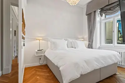 a white bedroom with a large white bed with white pillows at Vodickova Luxury Suites in Prague
