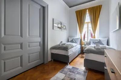 a bedroom with two twin beds and a door at 3 Bedroom - Central Superior-Flat 115m2 in Prague
