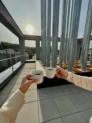 two people holding cups in their hands on a balcony at SYMPHONY No 501 Apartment MyMozart in Prague