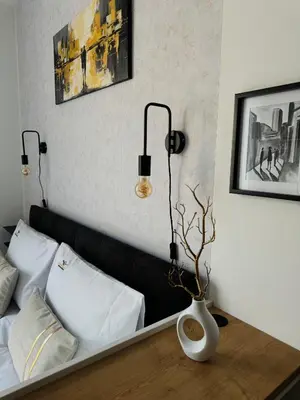 a bedroom with a black couch and a vase on a table at SYMPHONY No 501 Apartment MyMozart in Prague
