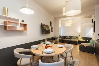 a dining room and living room with a table and chairs at Lighthouse Apartment in Prague